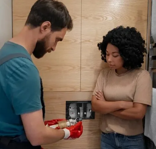 Plombier installant une toilette dans une salle de bain
